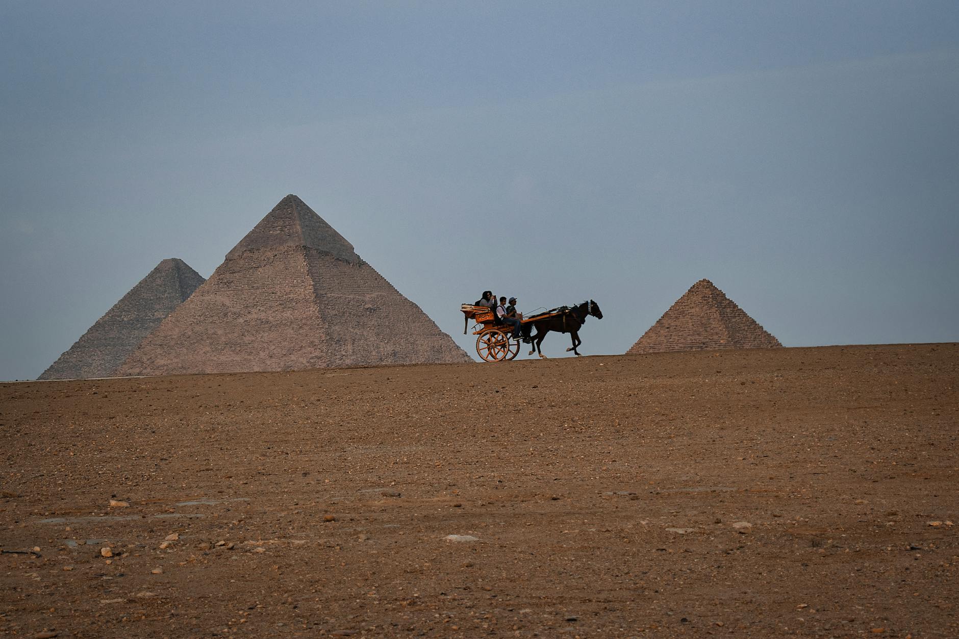 people riding a horse carriage by the pyramids giza egypt