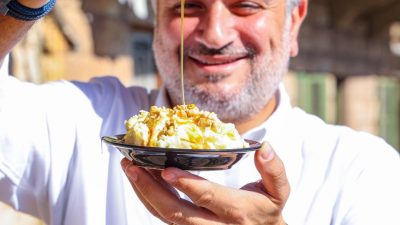 man in white long sleeves holding a plate of dessert