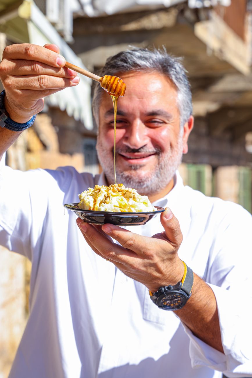 man in white long sleeves holding a plate of dessert