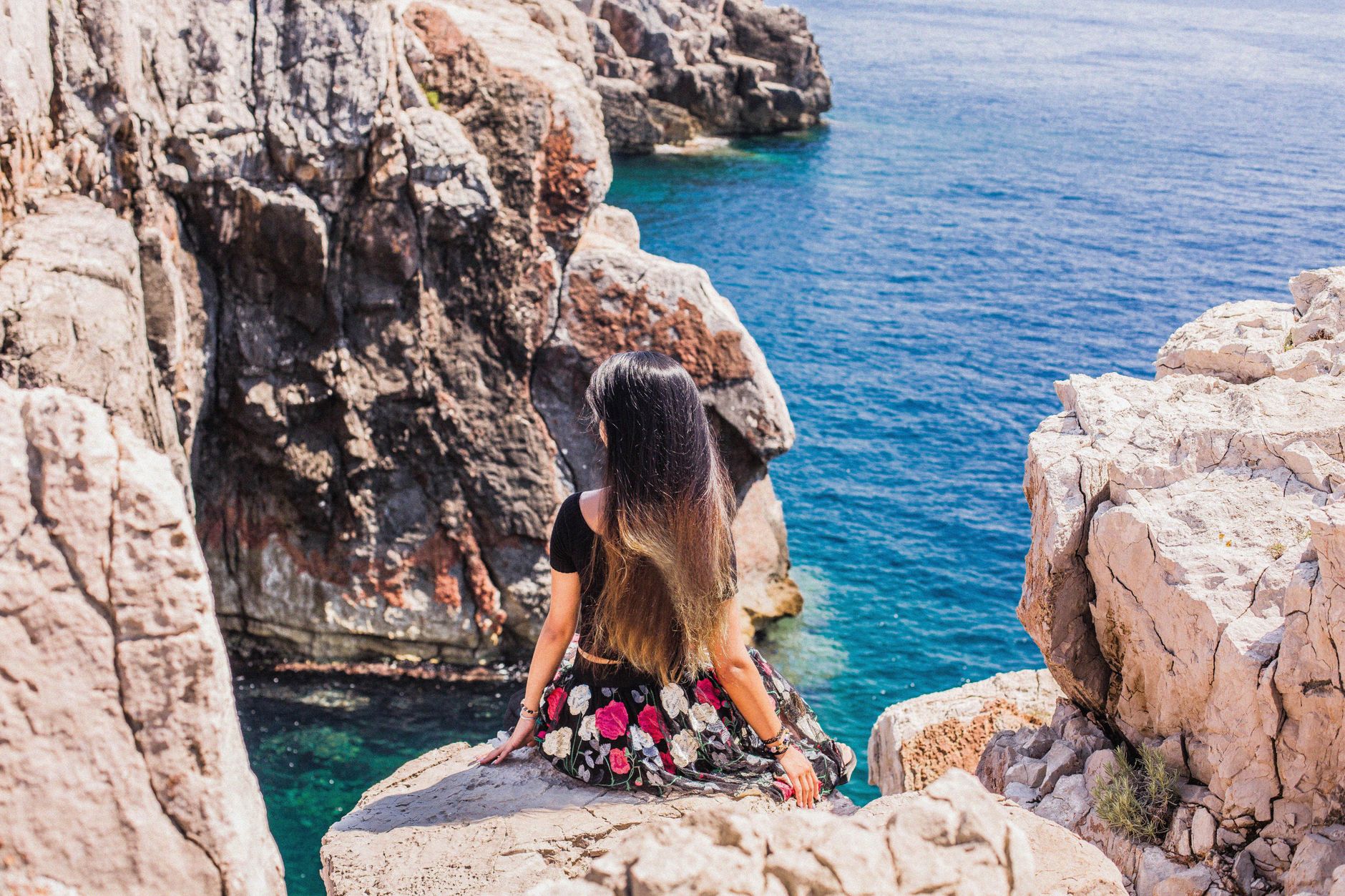 woman sitting at edge of rock