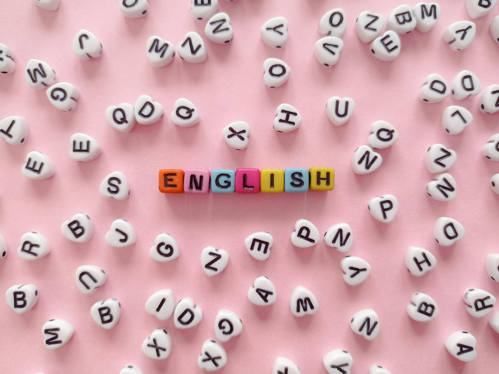 the word english made of beads with letters lying on pink background