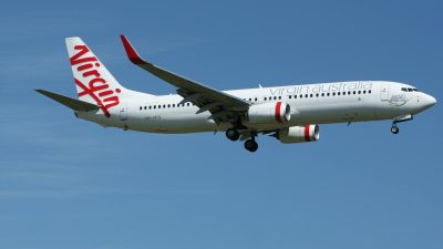 white and red virgin australia airplane mid air under blue and white sky during daytime