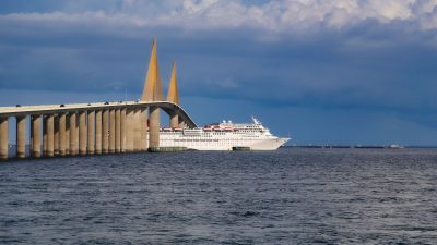 white cruise ship sailing on the sea under blue sky