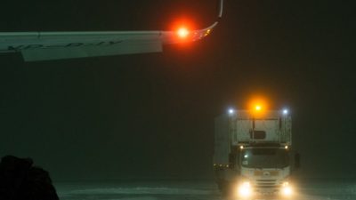 truck near an airplane wing on snow covered ground