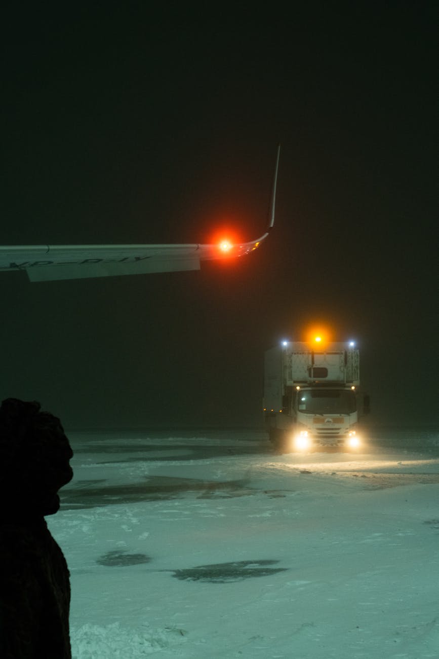 truck near an airplane wing on snow covered ground
