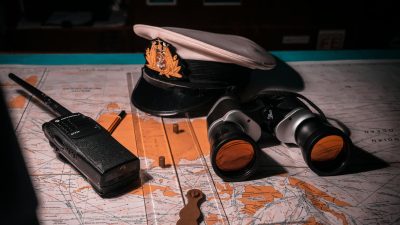 captains hat binoculars and walkie talkie left on the map