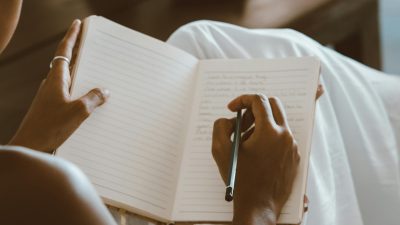 a person writing on a notebook