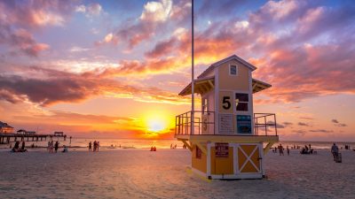 white and yellow wooden lifeguard house on beach during sunset