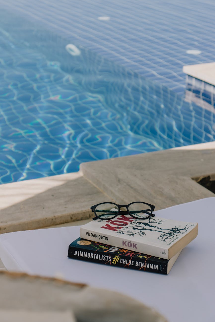 eyeglasses over books by the poolside