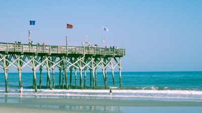 a pier with flags under blue sky