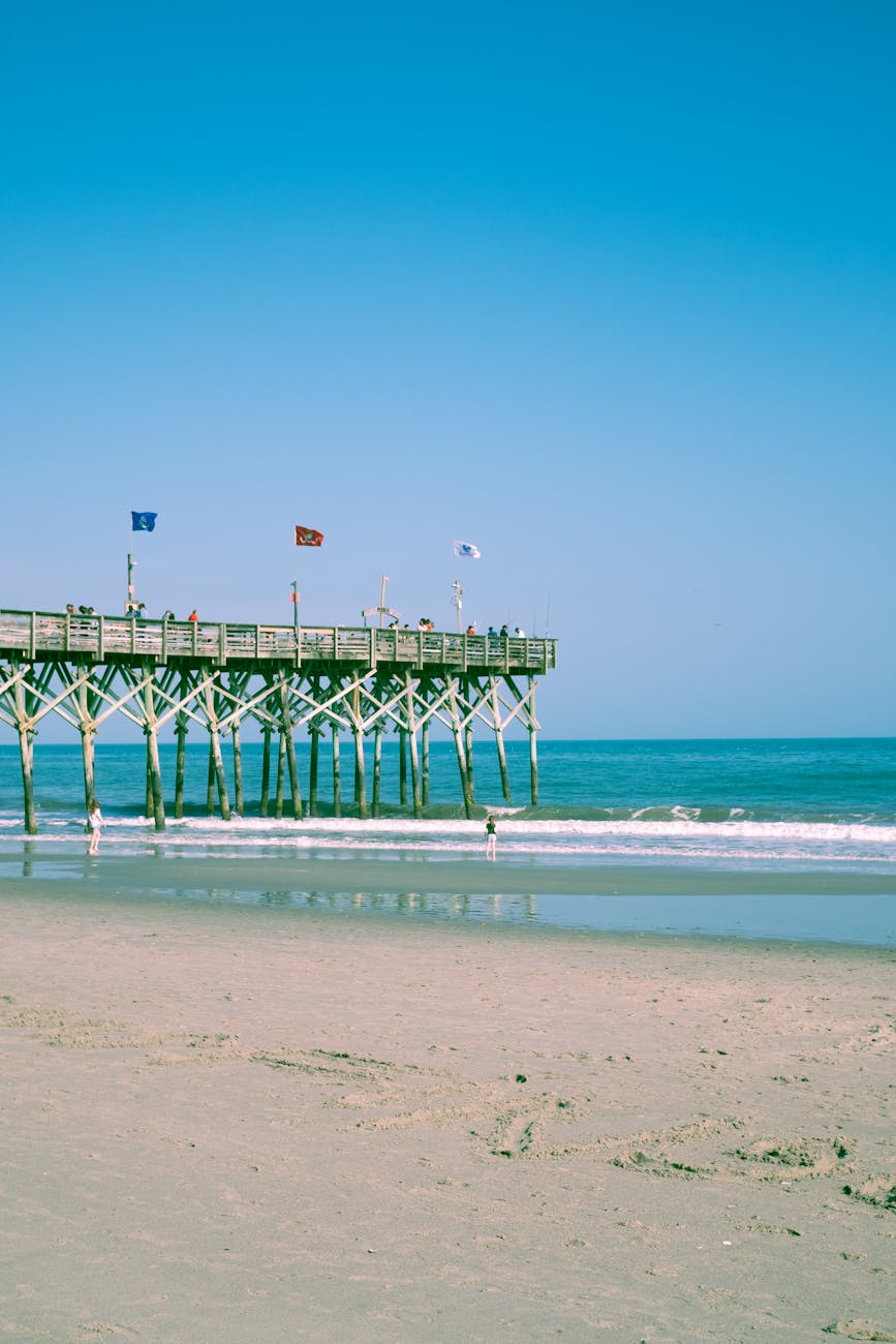 a pier with flags under blue sky