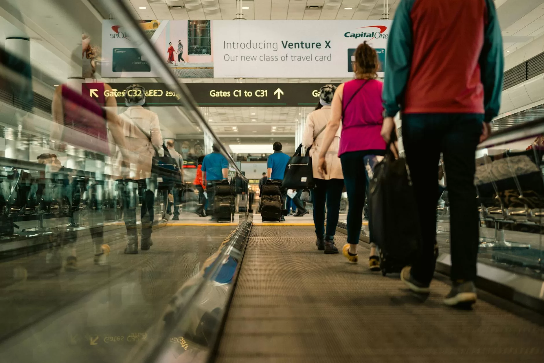 people using a moving walkway in an airport