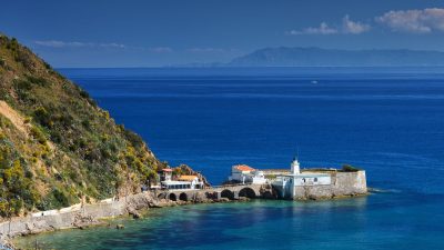 fortress on sea shore by hill
