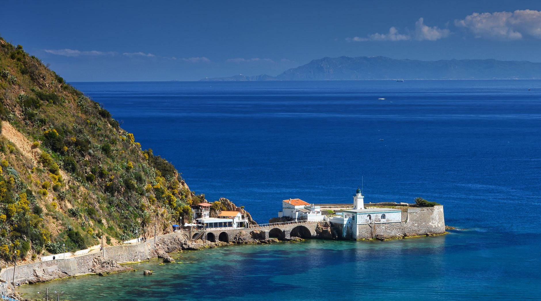 fortress on sea shore by hill