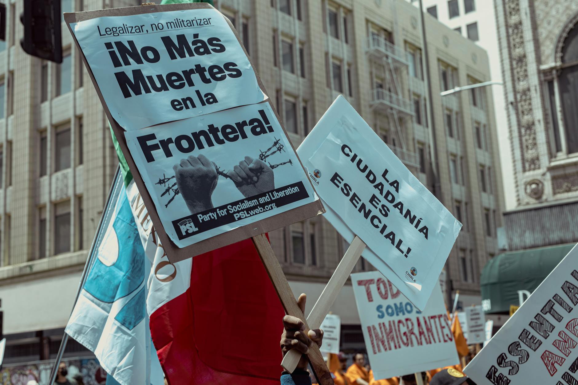 protesters holding banners while walking on a street in city