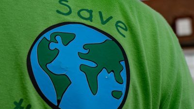 a man wearing green shirt with save the earth message