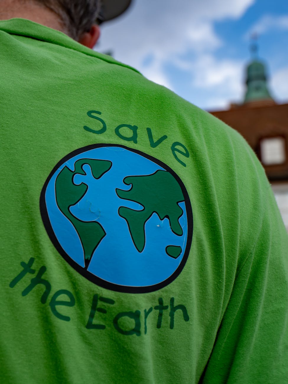 a man wearing green shirt with save the earth message