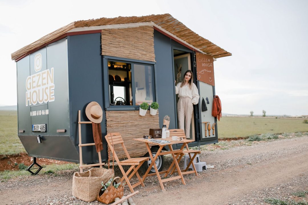 woman standing in a trailer converted to a house on wheels
