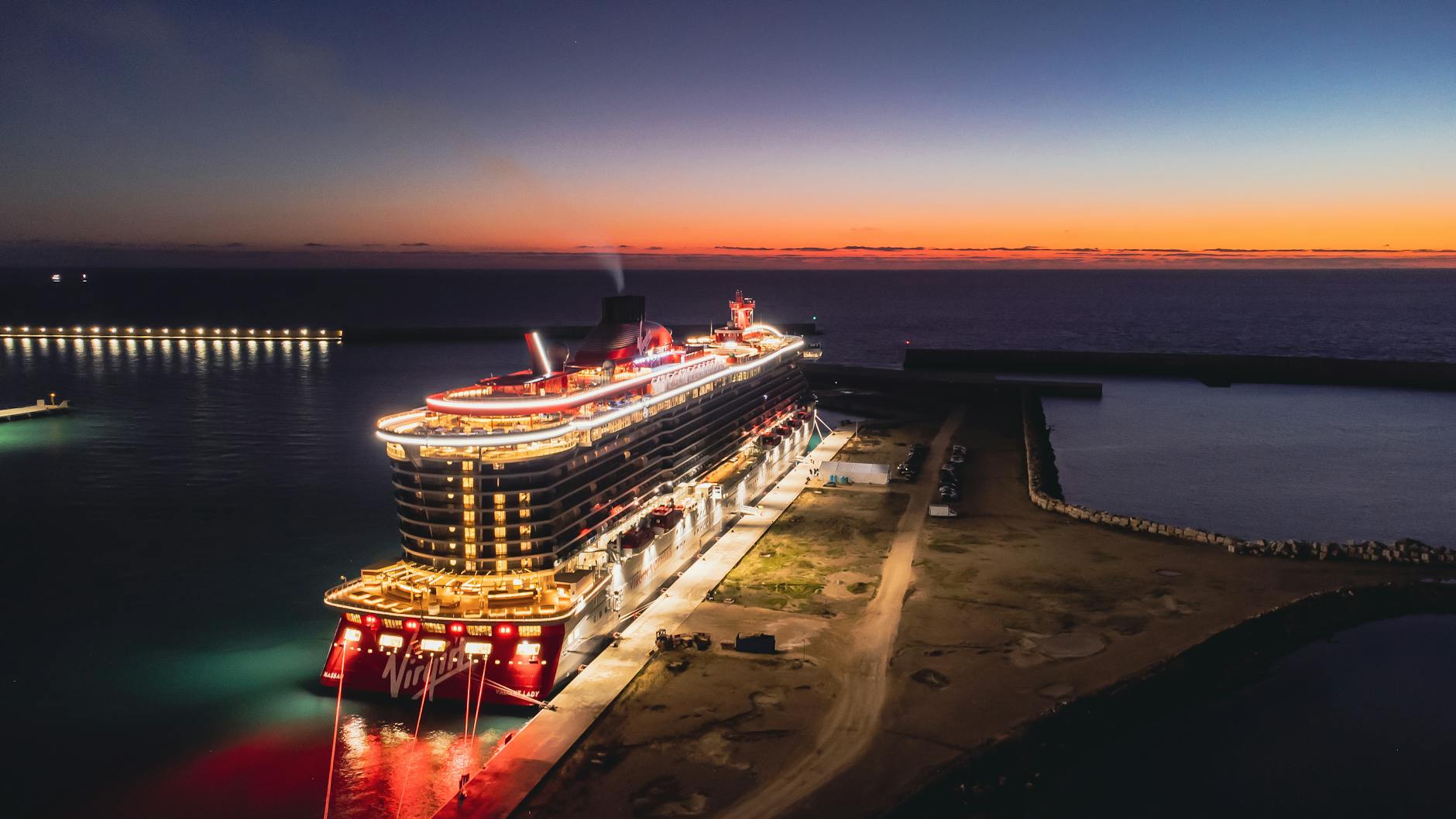 cruise ship with lights docked on a pier
