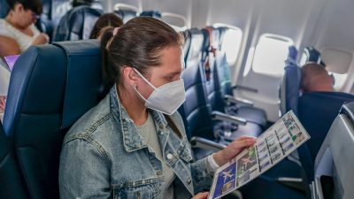 woman in denim jacket sitting inside the plane