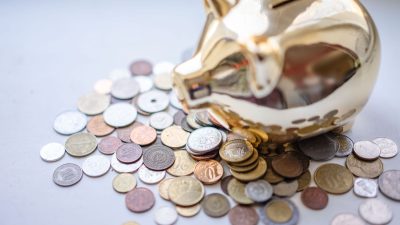 silver and gold coins near piggy bank