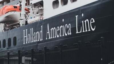 cruise ship docked at port with lifeboats visible