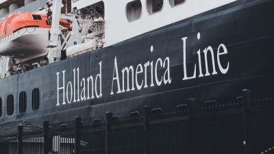 cruise ship docked at port with lifeboats visible