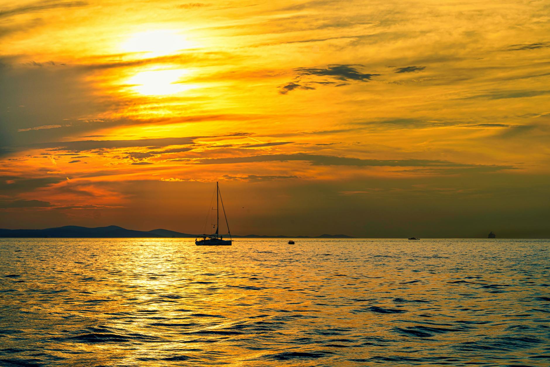 silhouette of boat on body of water during sunset