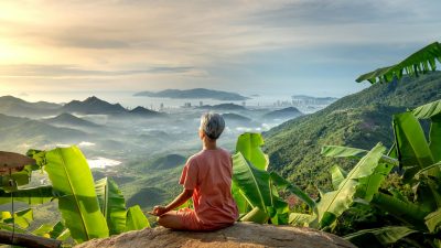 woman looking at beautiful landscape and doing yoga
