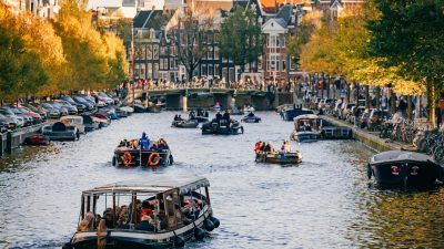 people riding boats on a water canal