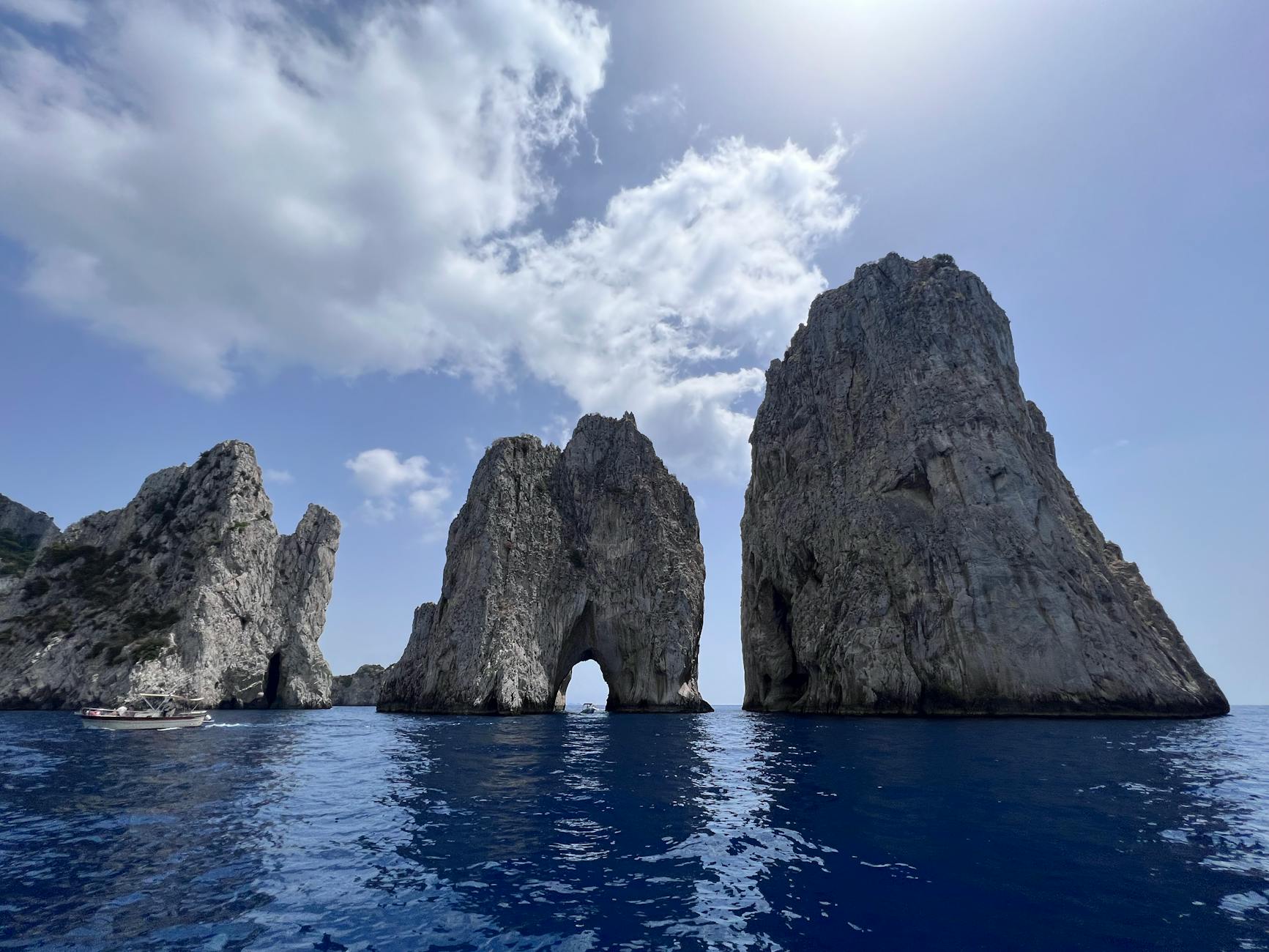 cloud on blue sky over rock formations on sea shore