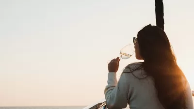 woman drinking and sailing at sunset
