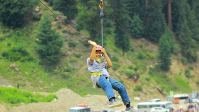 woman on a zip line smiling and waving