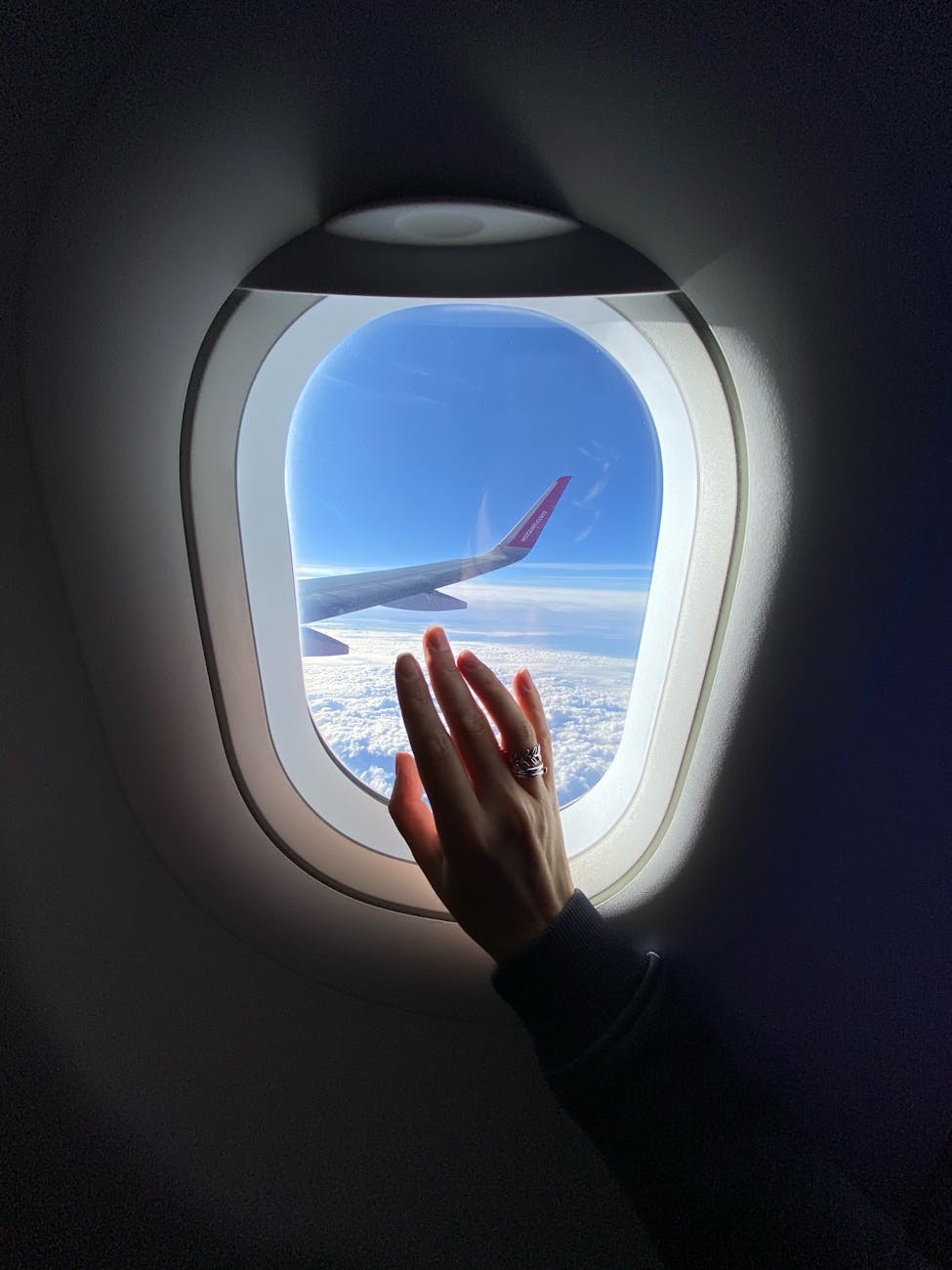 girl s hand on the porthole in the plane in flight