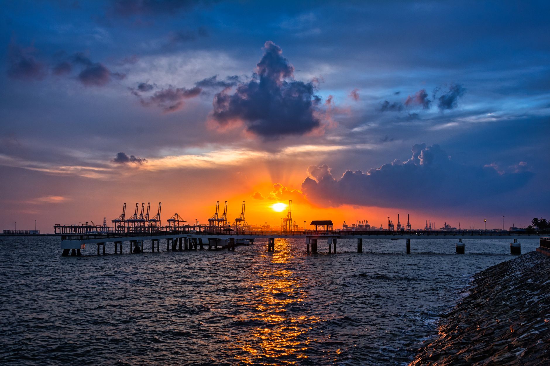 silhouette of a jetty and sea at sunset