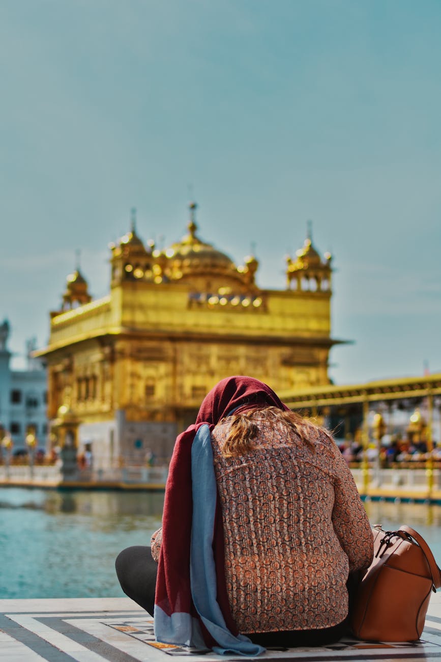 back view of a woman sitting near the golden temple amritsar punjab india