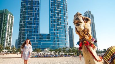 camel and woman on beach in dubai