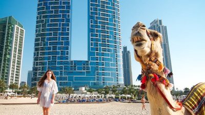 camel and woman on beach in dubai