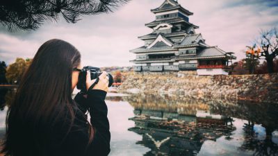 female photographer taking photo of a temple