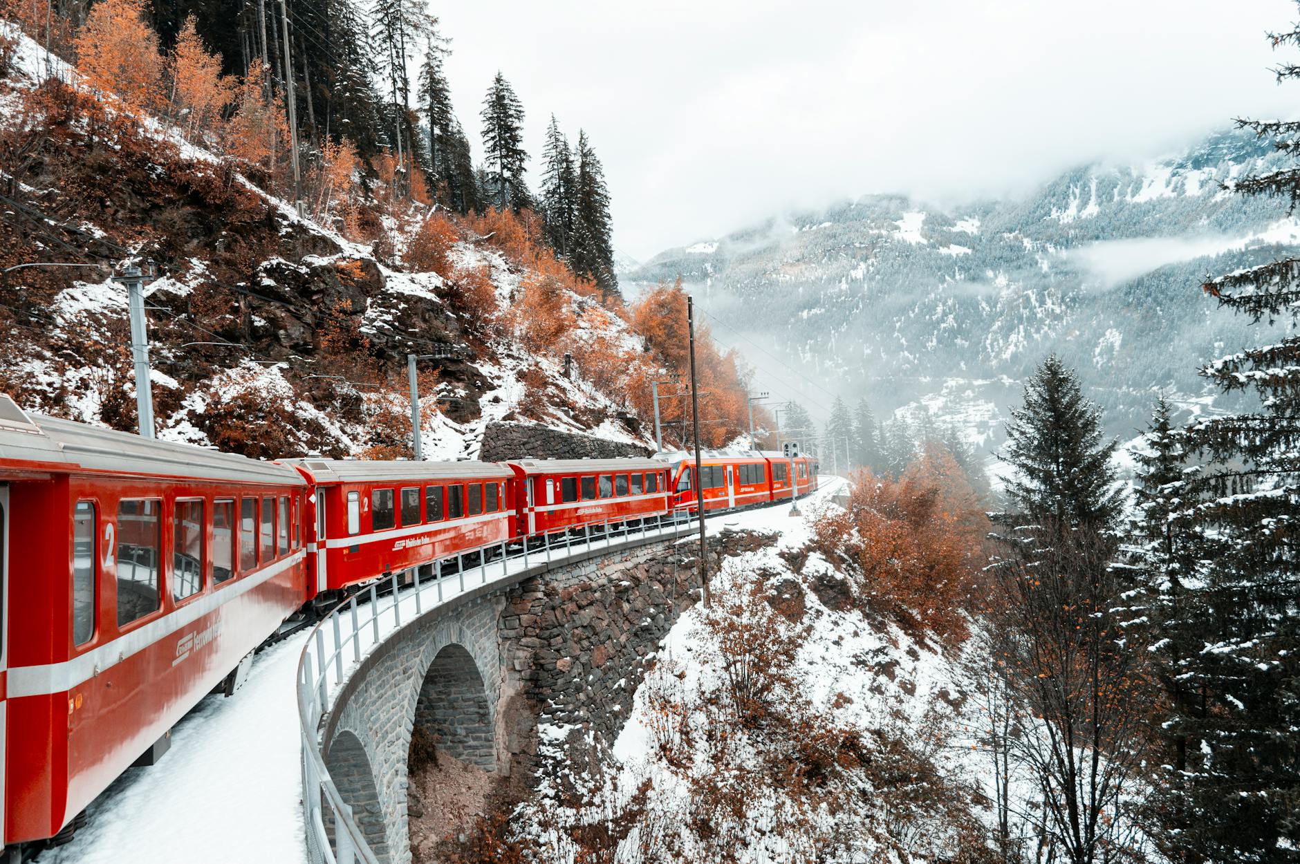 red train in a mountain valley