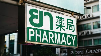 a pharmacy sign hanging from a building