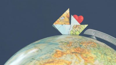paper ship on globe