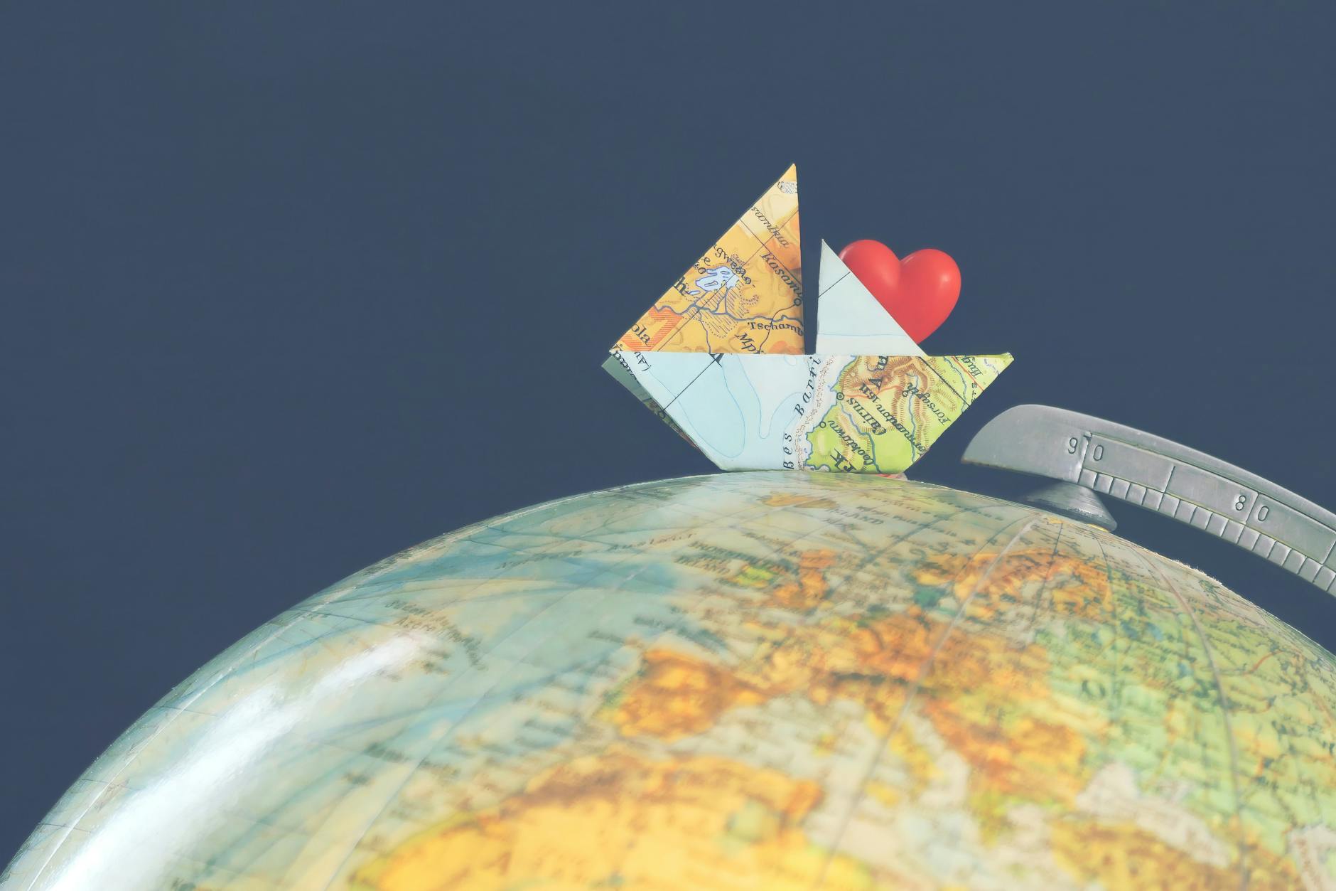 paper ship on globe