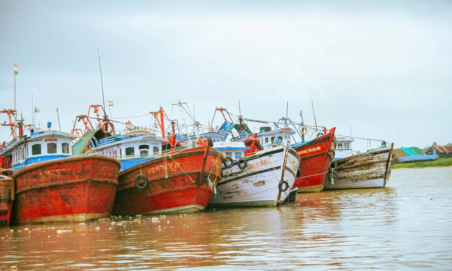 red and white weathered boats moored at a coast
