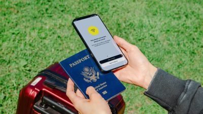 close up of a person holding a passport and a smartphone