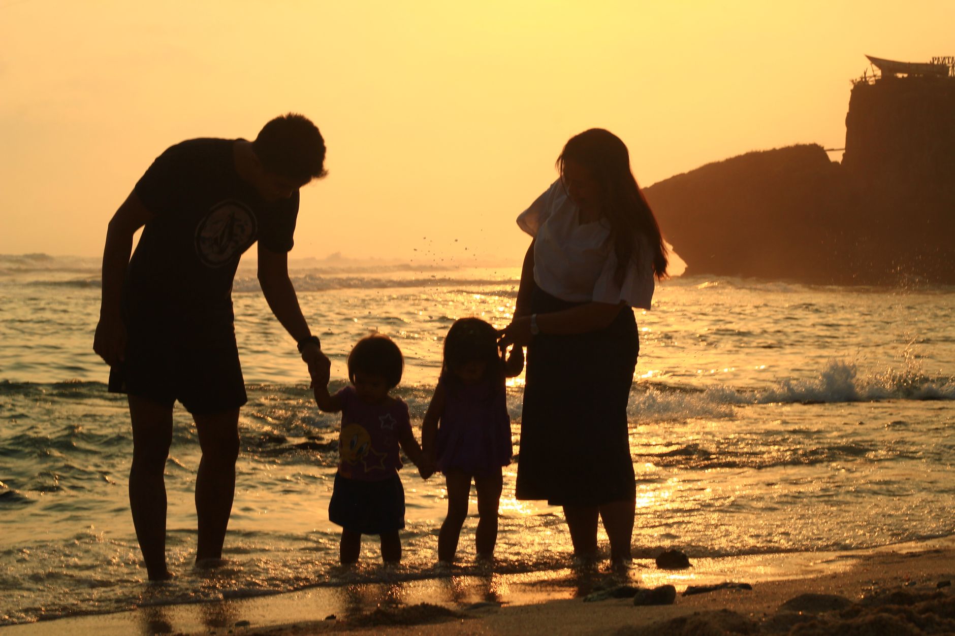 silhouettes of a family at the beach