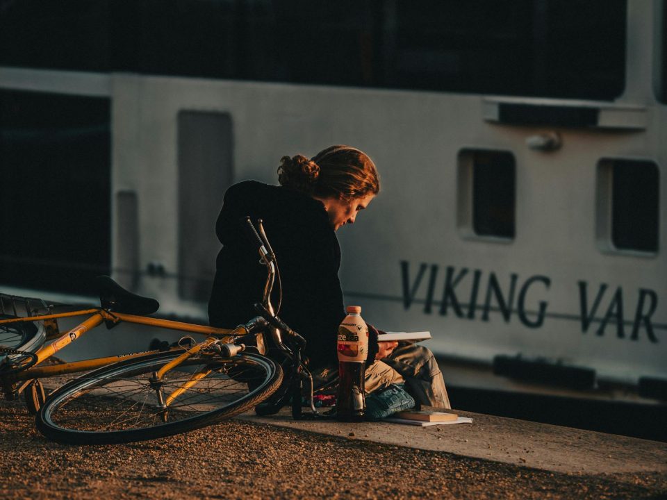 a person sitting on a shore and reading a book