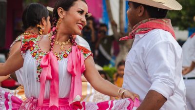 people wearing traditional mexican clothing dancing together