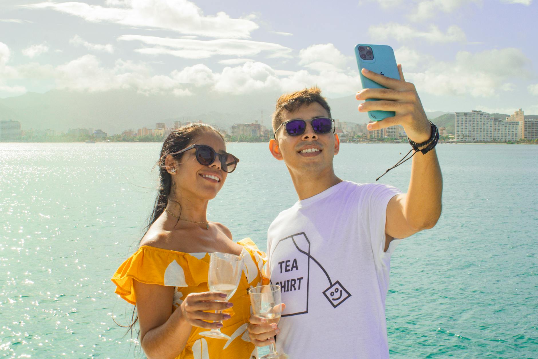 couple taking selfie with drink on sea shore
