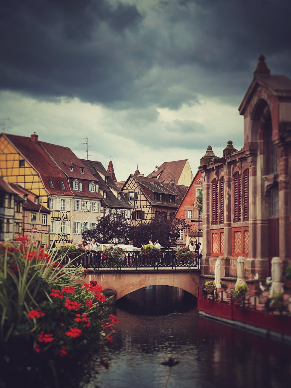 a river and buildings in a city under a cloudy sky